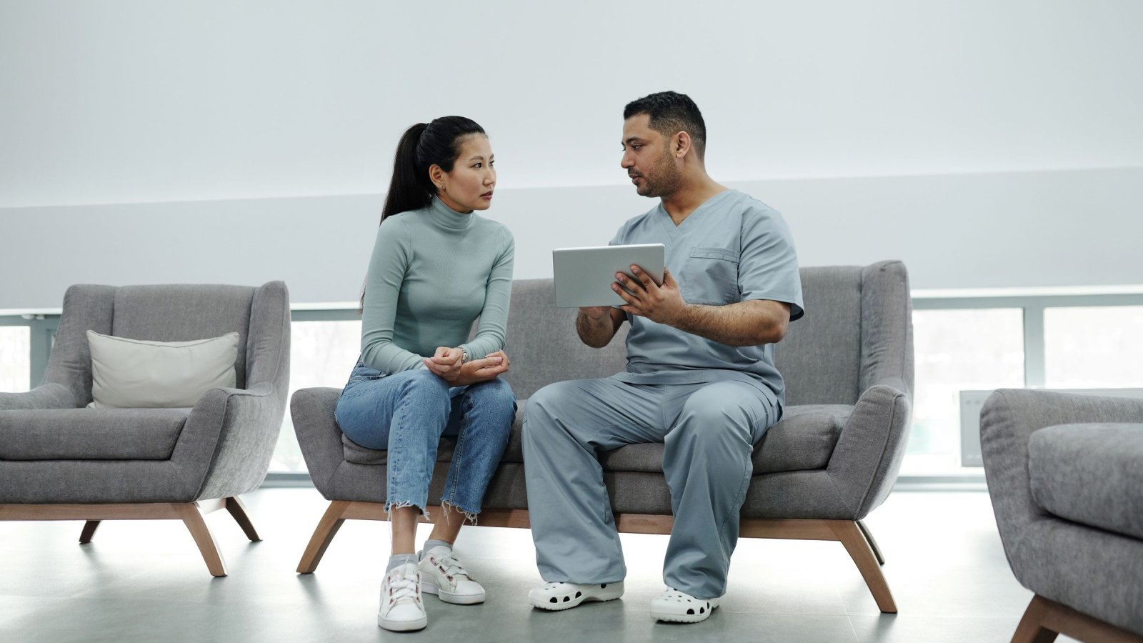 Healthcare provider consulting a patient with a tablet, emphasizing technology in healthcare.