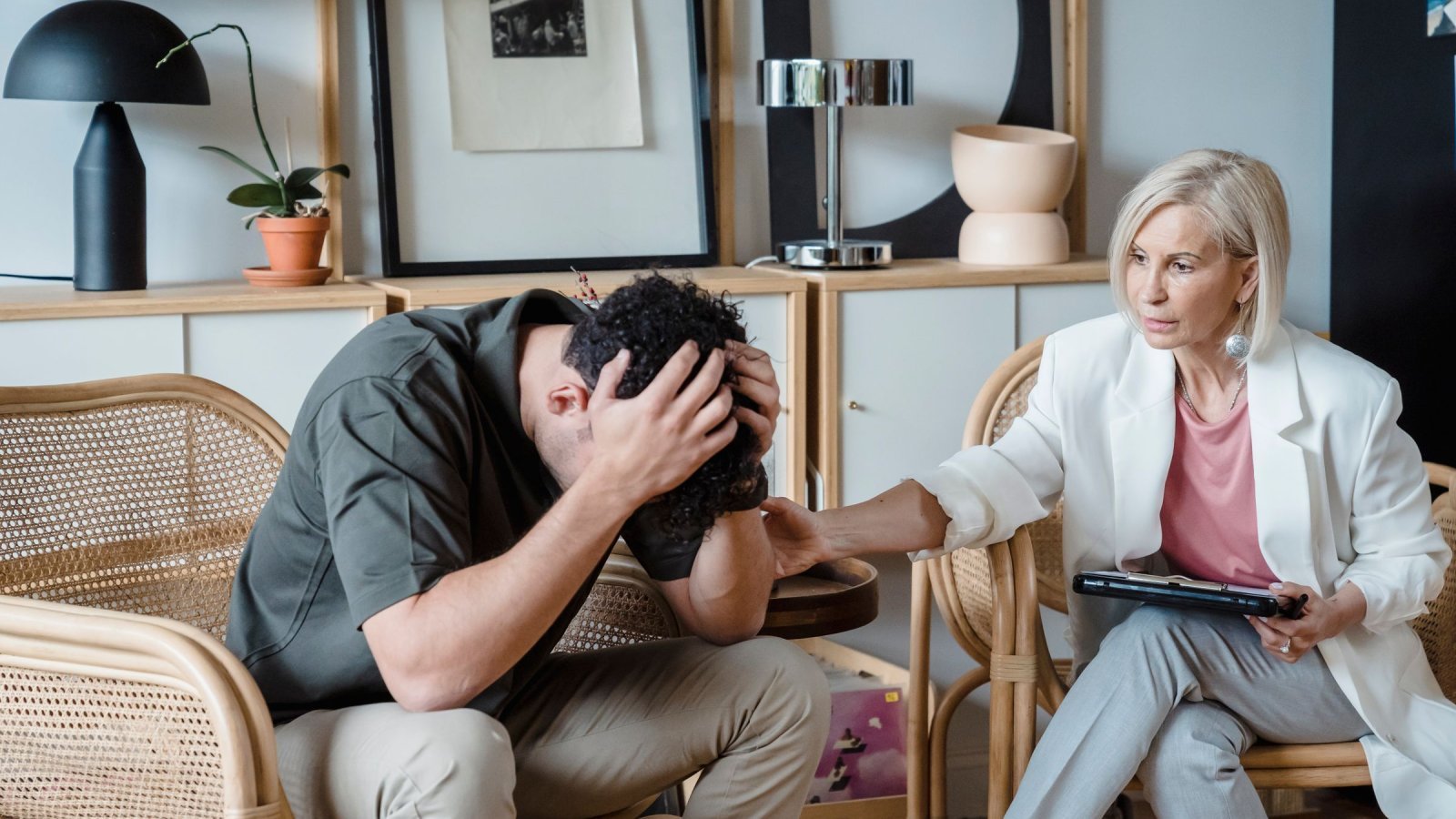 A supportive therapist provides comfort during a counseling session in a cozy office.